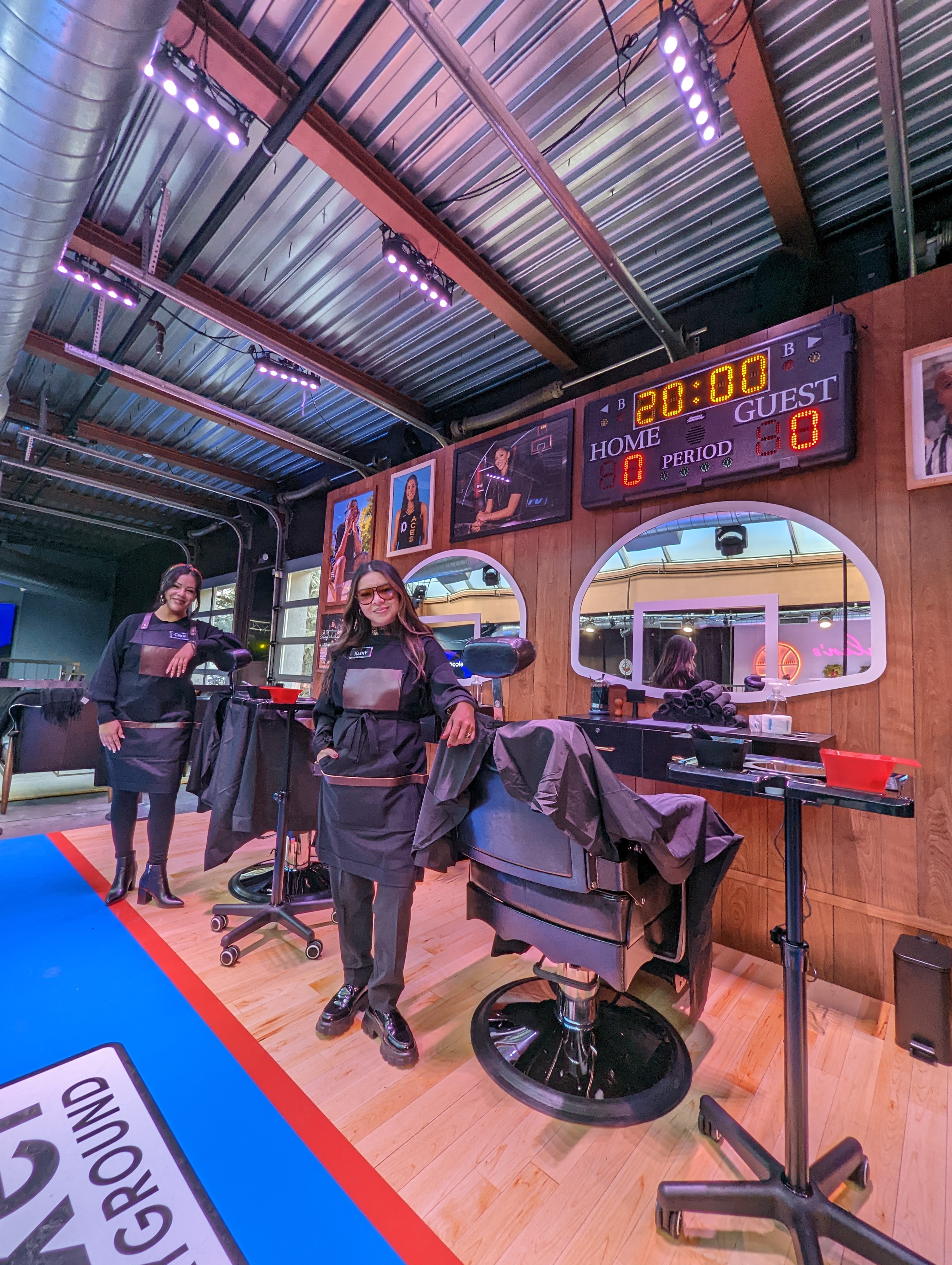 Stylist posing by their chairs in the NBA Barbershop.