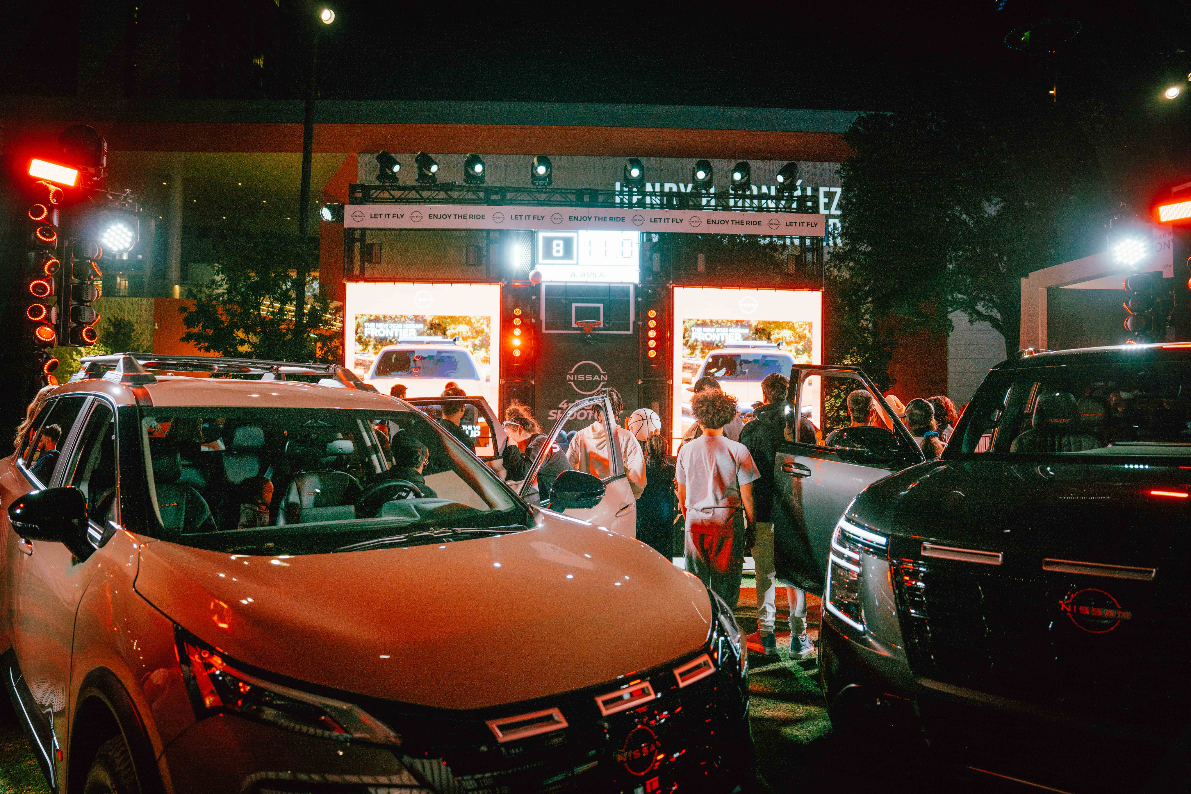 Night shot of patrons viewing the Nissan Car showcase.