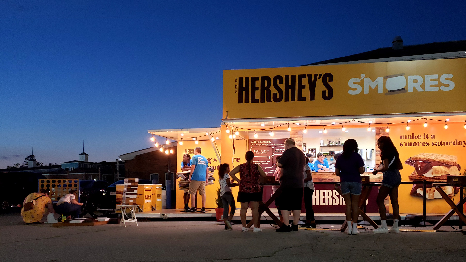 Guests wait in line outside of the Hershey's S'mores footprint at night