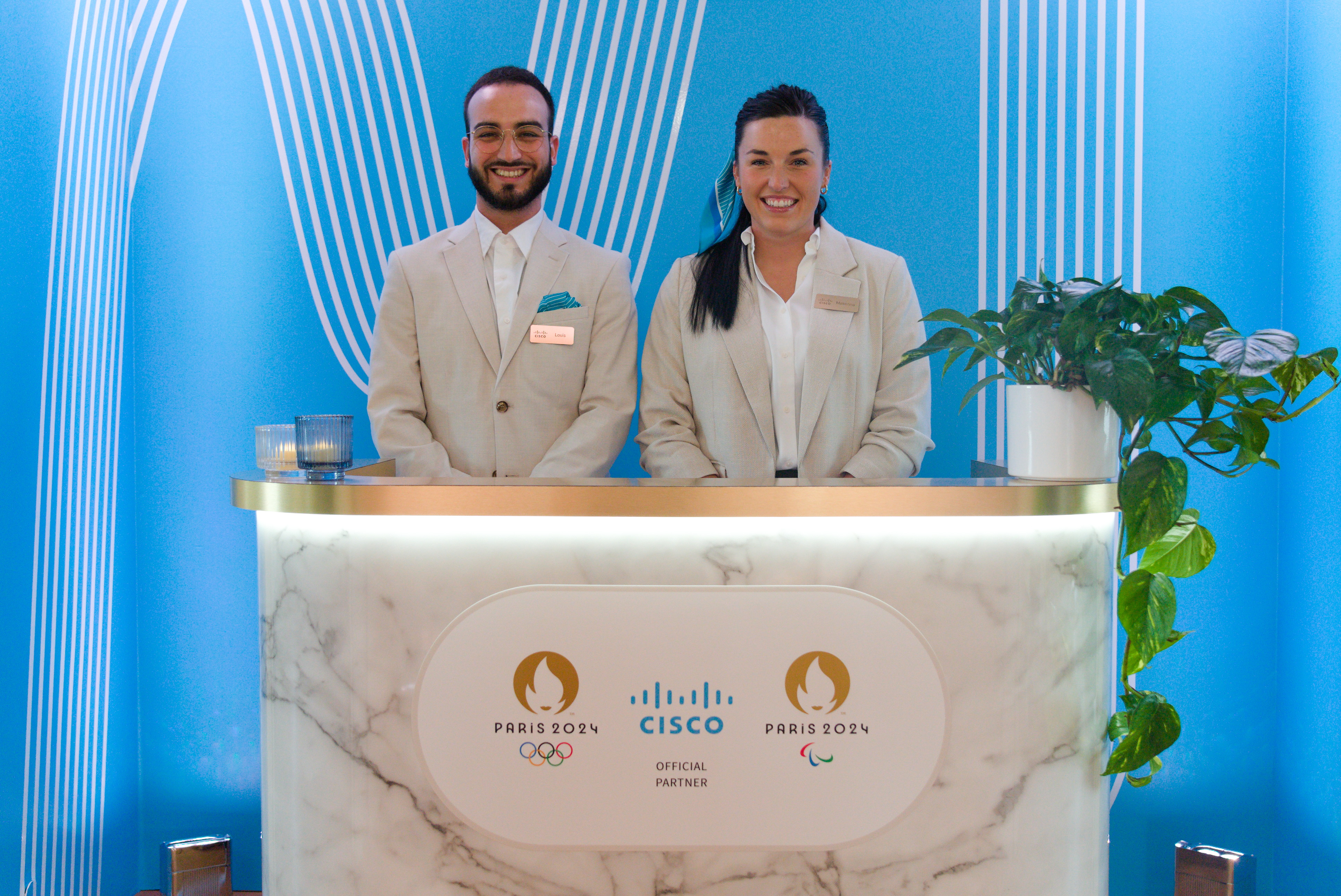 Two concierges behind bar set at Cisco Olympics Lounge